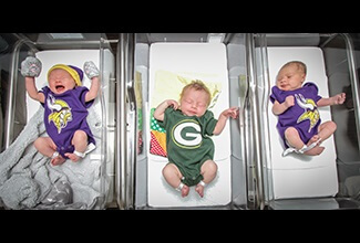 baby in greenbay packers jersey in between two babies with minnesota vikings jerseys on