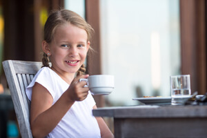 Young girl holding a coffee cup.