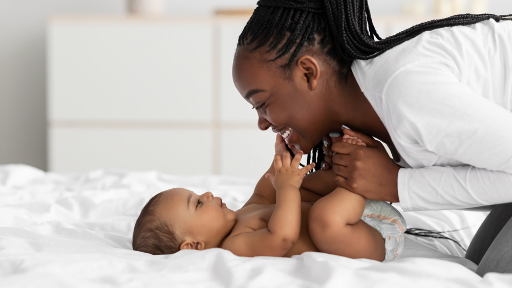 Black mom smiling at baby